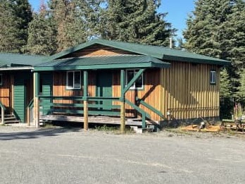 An Albatross wooden cabin with a covered green porch